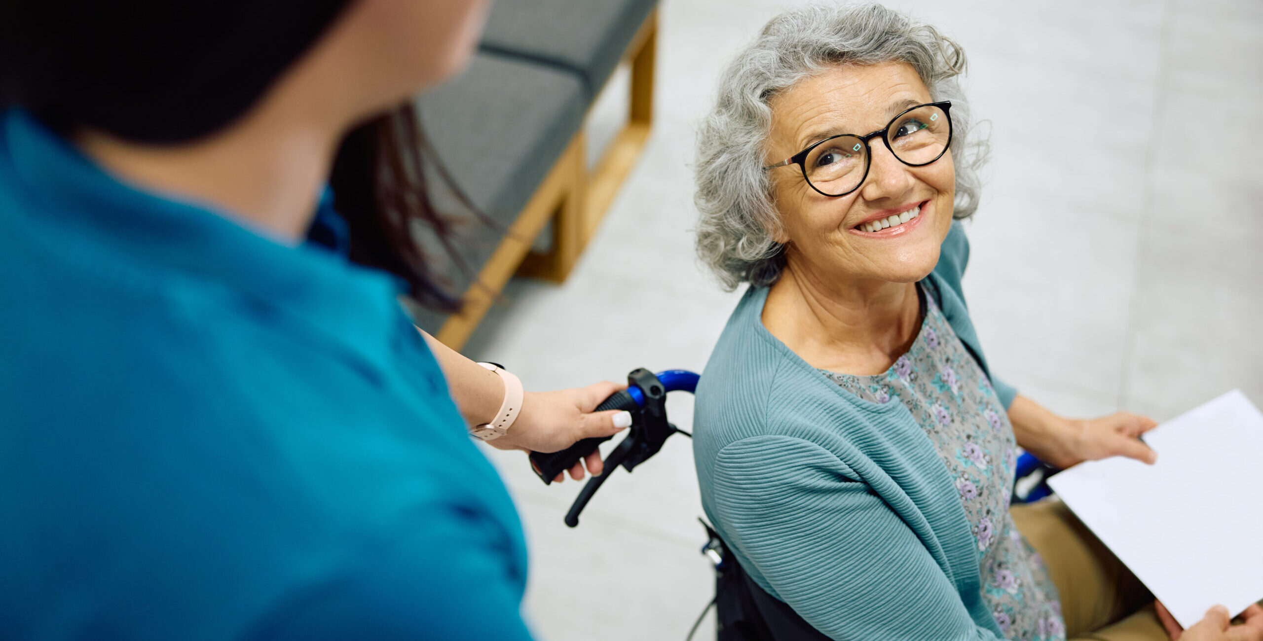 happy-senior-woman-in-wheelchair-being-pushed-by-a-2024-01-29-21-45-25-utc (1)